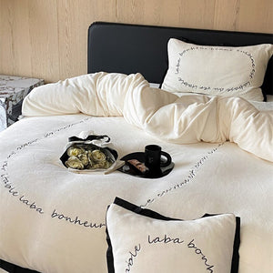 VILZSTUDIOS neutral fleece bedding set with black piping and cursive embroidery