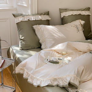 VILZSTUDIOS cream and sage green bedding set with lily-of-the-valley embroidery, lace detailing and layered ruffle trims