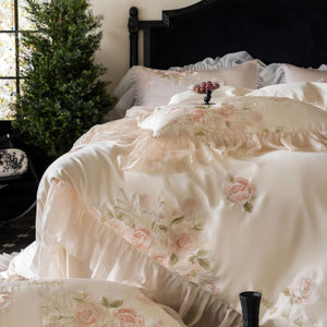 VILZSTUDIOS pale blush pink satin bedding set with rose embroidery and sheer ruffled edges