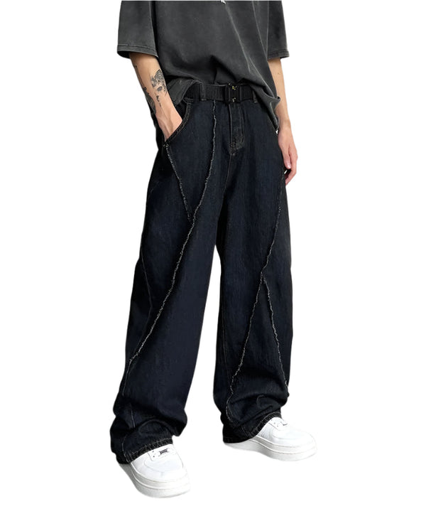 Person wearing black oversized pants and white sneakers on a plain background