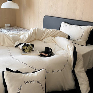 VILZSTUDIOS neutral fleece bedding set with black piping and cursive embroidery