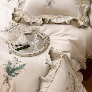 VILZSTUDIOS cream and sage green bedding set with lily-of-the-valley embroidery, lace detailing and layered ruffle trims